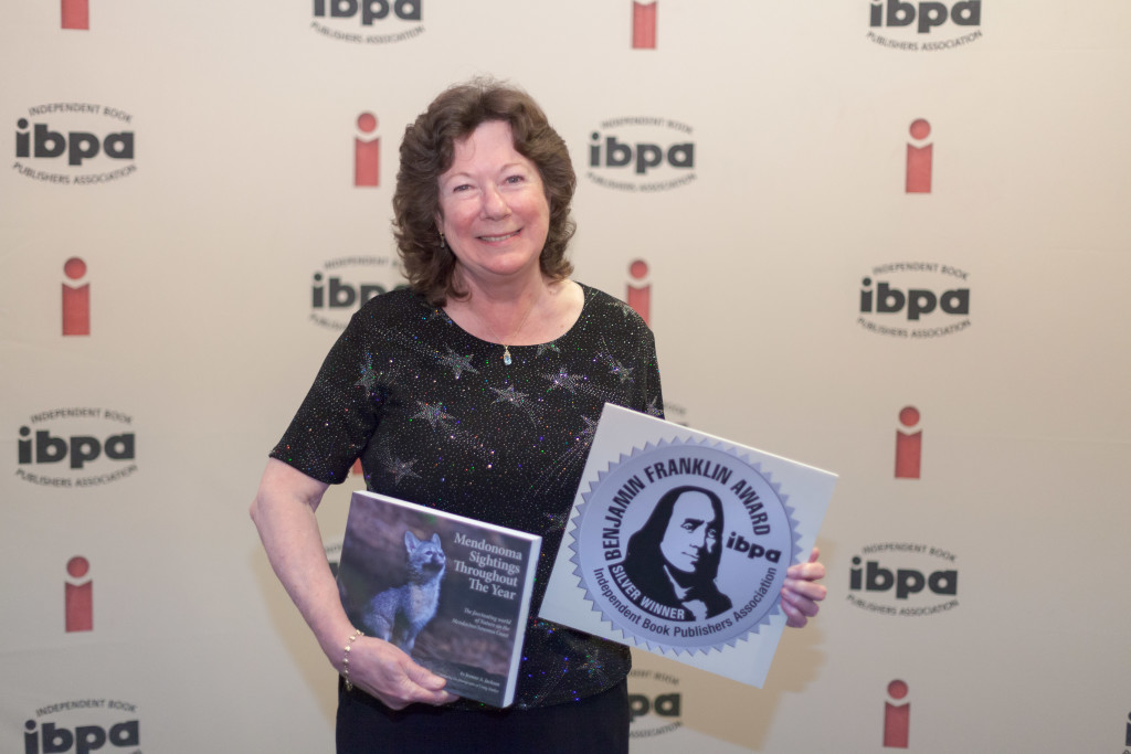 Jeanne Jackson with her book, Mendonoma Sightings Throughout the Year, wins the silver Benjamin Franklin book award, photo courtesy of IBPA