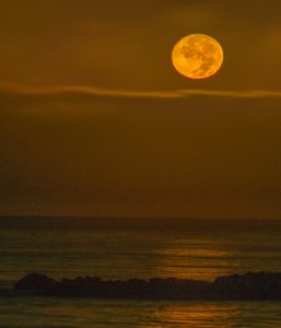 harvest-moon-setting-over-ocean-by-paul-brewer